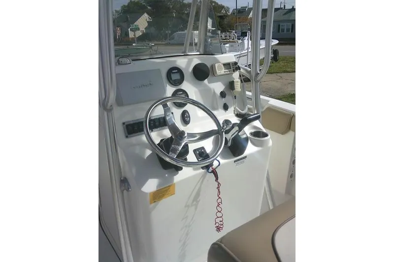 Slide: The Image of 2017 Key West 203 FS boat console with steering wheel and navigation controls. - 43