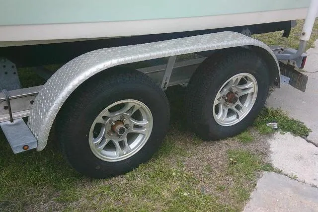 Slide: The Image of Trailer wheels of a 2017 Key West 203 FS boat on grass. - 6