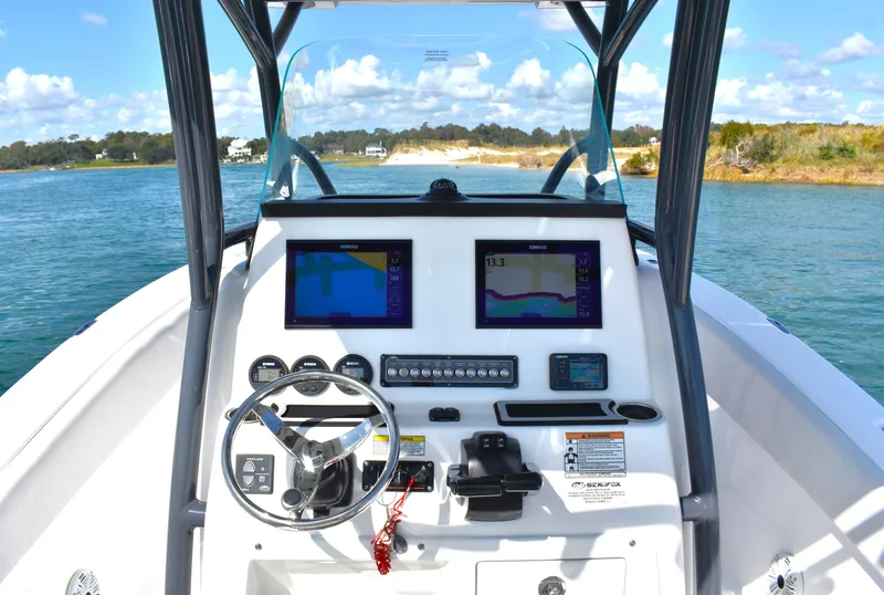 Slide: The Image of 2020 Sea Fox 266 Commander boat dashboard with dual navigation screens on open water. - 14