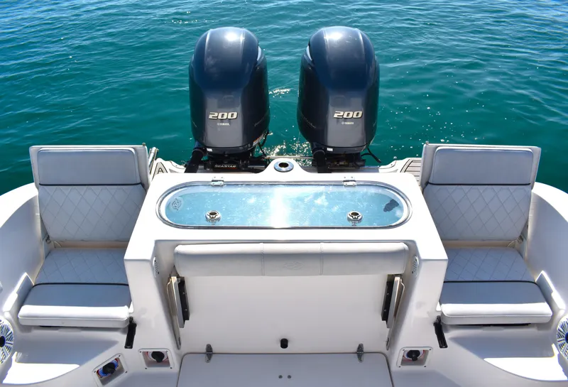 Slide: The Image of 2020 Sea Fox 266 Commander boat with twin engines and seating, on clear blue water. - 20