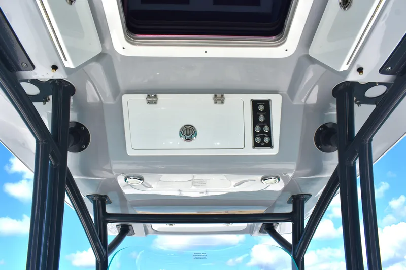 Slide: The Image of 2020 Sea Fox 266 Commander boat console with storage and controls, under a clear blue sky. - 24