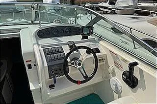 Slide: The Image of 1995 Sea Ray 250 Sundancer boat cockpit with steering wheel and control panel. - 10