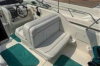 Slide: The Image of 1995 Sea Ray 250 Sundancer boat interior with white seating and teal carpet. - 12