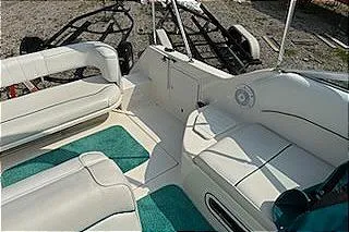 Slide: The Image of 1995 Sea Ray 250 Sundancer boat interior with white seating and teal carpet. - 13