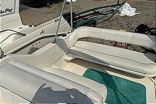Slide: The Image of 1995 Sea Ray 250 Sundancer boat interior with white seating and teal carpet. - 14