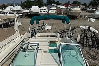 Slide: The Image of 1995 Sea Ray 250 Sundancer boat docked in a marina with other vessels. - 16