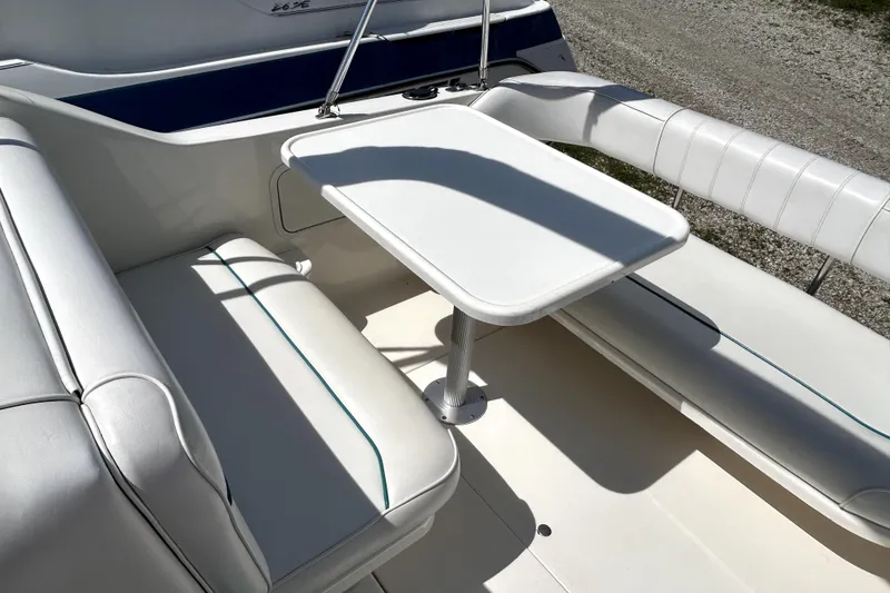 Slide: The Image of Interior seating area of a 1995 Sea Ray 250 Sundancer boat with white upholstery. - 19