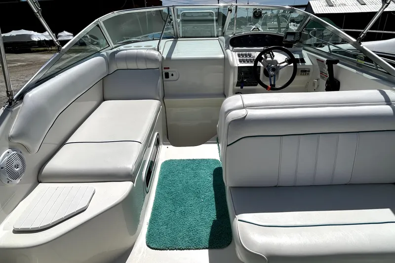 Slide: The Image of Interior of a 1995 Sea Ray 250 Sundancer boat with white seating and green carpet. - 24
