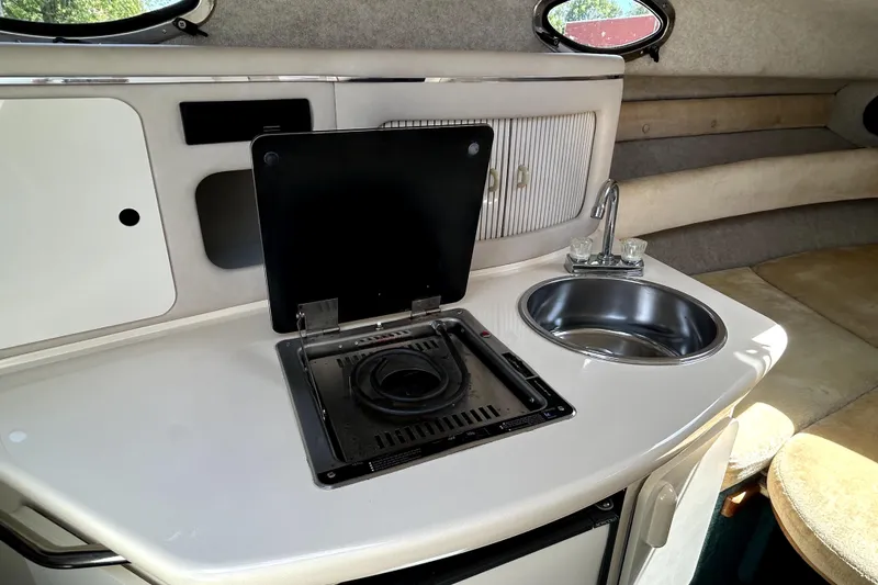 Slide: The Image of Interior of 1995 Sea Ray 250 Sundancer with kitchenette, stove, and sink. - 26