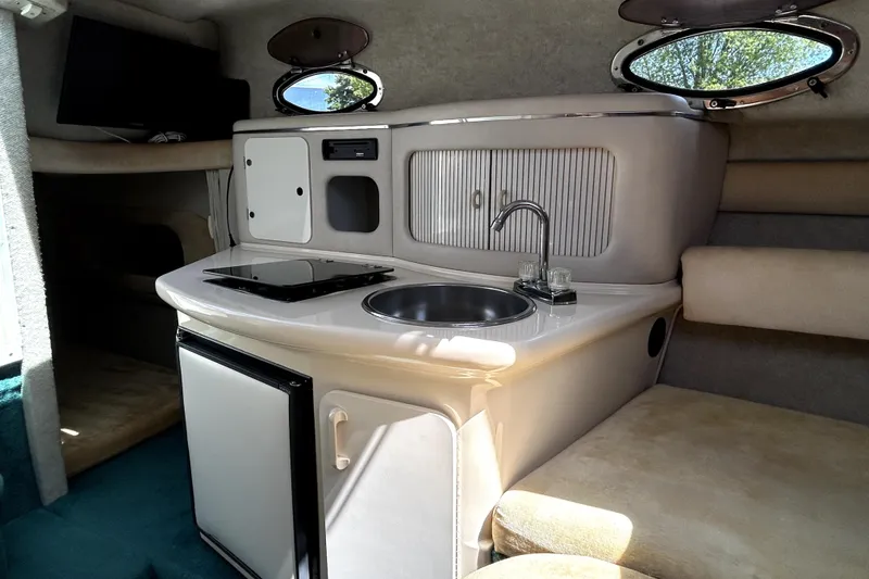 Slide: The Image of Interior of a 1995 Sea Ray 250 Sundancer boat with kitchenette and seating area. - 28