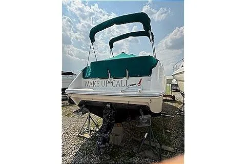 Slide: The Image of 1995 Sea Ray 250 Sundancer boat with green canopy, named "Wake Up Call," on dry dock. - 3