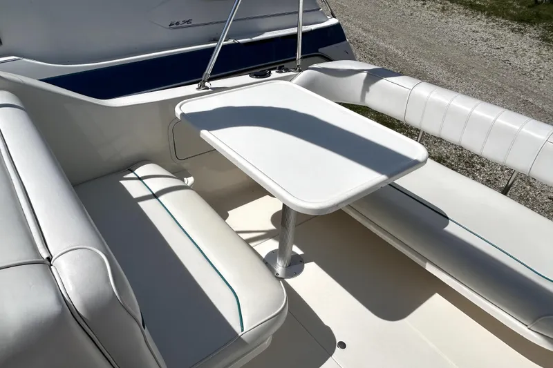 Slide: The Image of Interior seating area of a 1995 Sea Ray 250 Sundancer boat with white upholstery. - 32