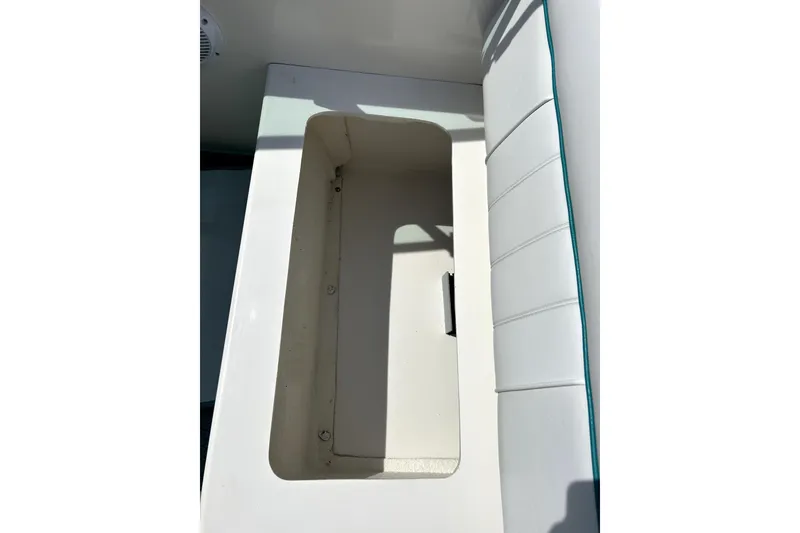 Slide: The Image of Open storage compartment on 1995 Sea Ray 250 Sundancer boat with white seating. - 33