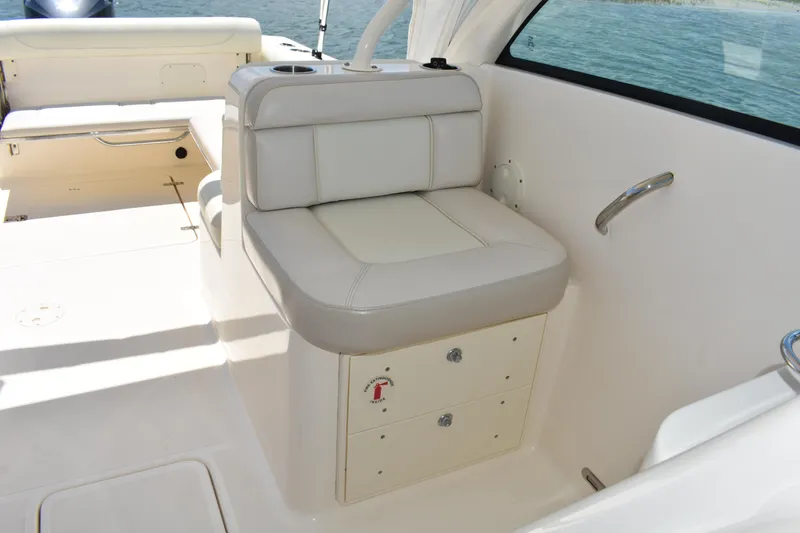 Slide: The Image of 2012 Pursuit DC 265 Dual Console boat interior with cushioned seating and storage. - 19