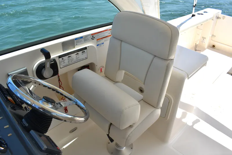 Slide: The Image of 2012 Pursuit DC 265 Dual Console boat interior with captain's chair and steering wheel. - 20