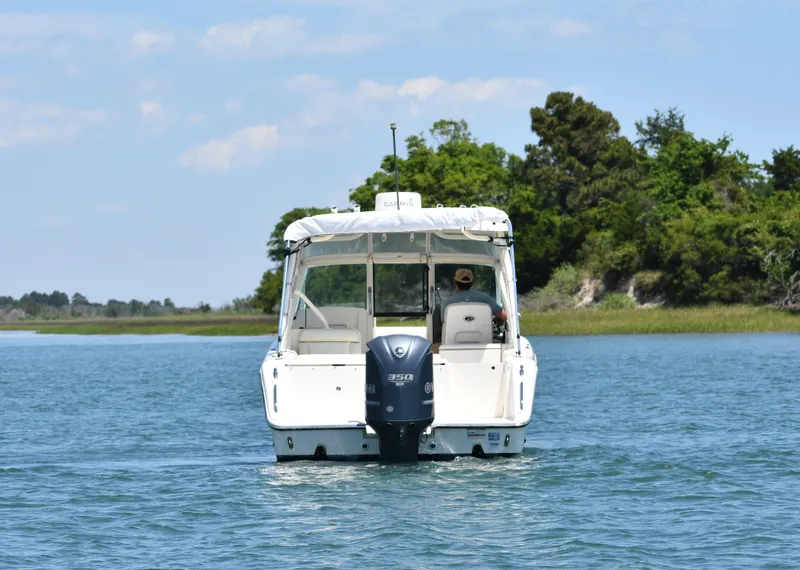 Slide: The Image of 2012 Pursuit DC 265 Dual Console boat cruising on a serene lake. - 8