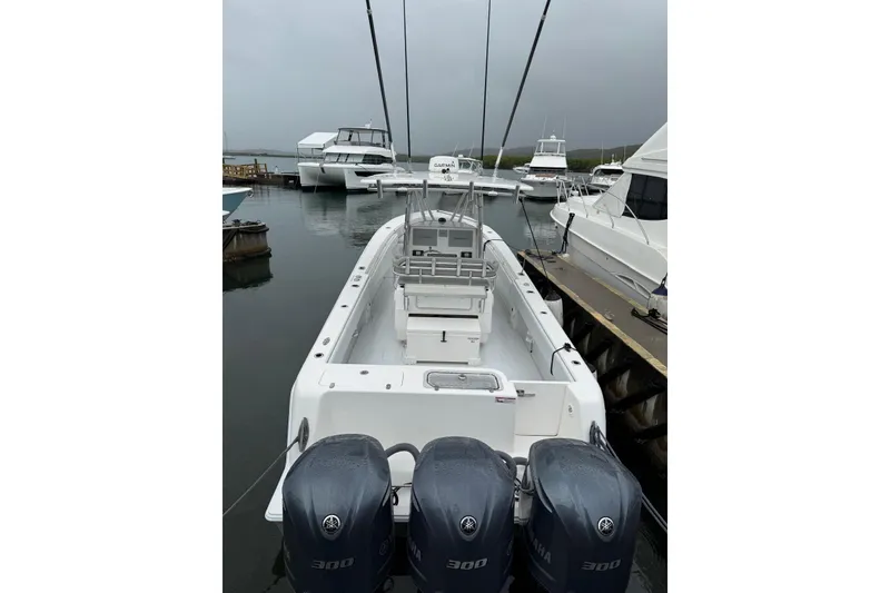 Slide: The Image of 2020 Contender 35 ST boat with triple Yamaha 300 engines docked at marina. - 2