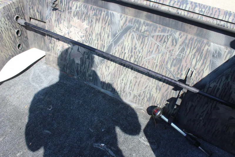 Slide: The Image of Interior of 2014 Lowe Roughneck 1756 boat with camouflage design and fishing rod holder. - 11