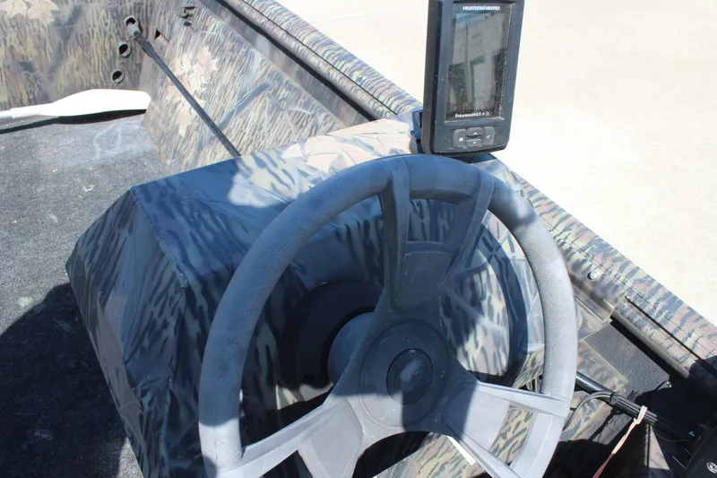 Slide: The Image of Steering console of 2014 Lowe Roughneck 1756 boat with camouflage design and fish finder. - 14