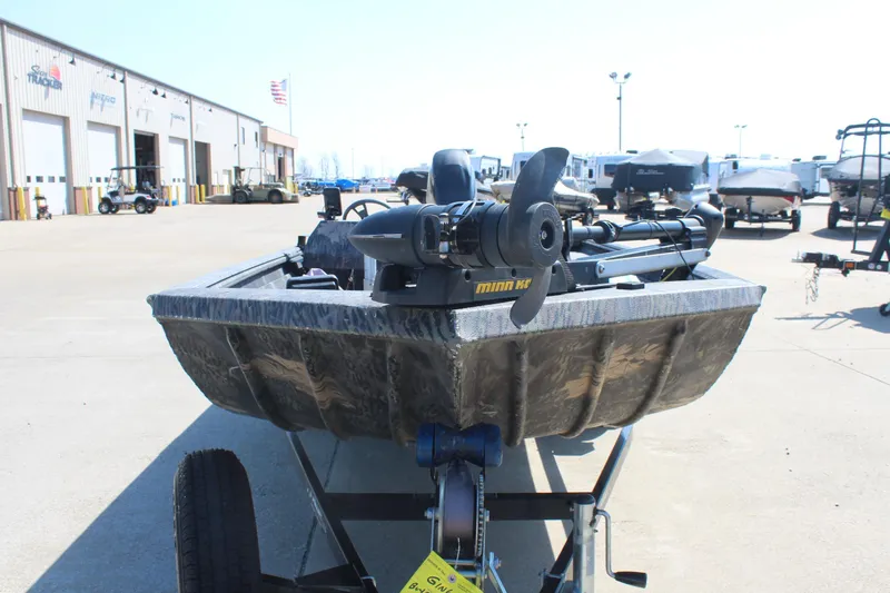 Slide: The Image of 2014 Lowe Roughneck 1756 boat on trailer, featuring Minn Kota motor, parked outside dealership. - 2