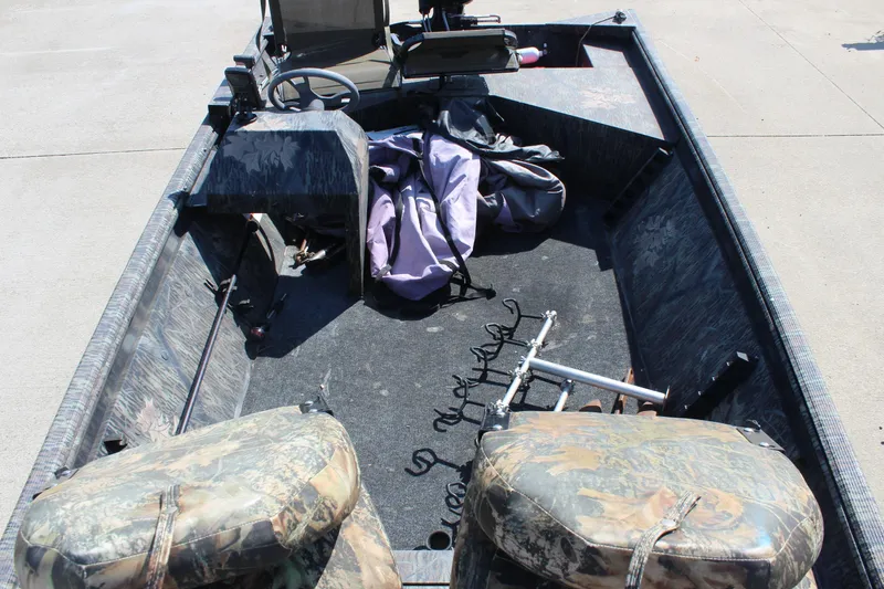 Slide: The Image of 2014 Lowe Roughneck 1756 boat interior with camo seats and fishing gear. - 20