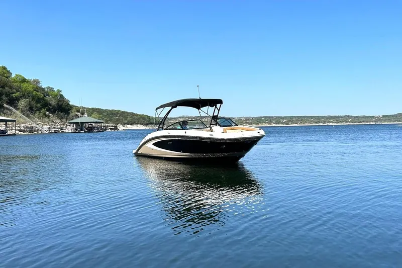 Slide: The Image of 2015 Sea Ray 270 Sundeck boat on calm lake under clear blue sky. - 12