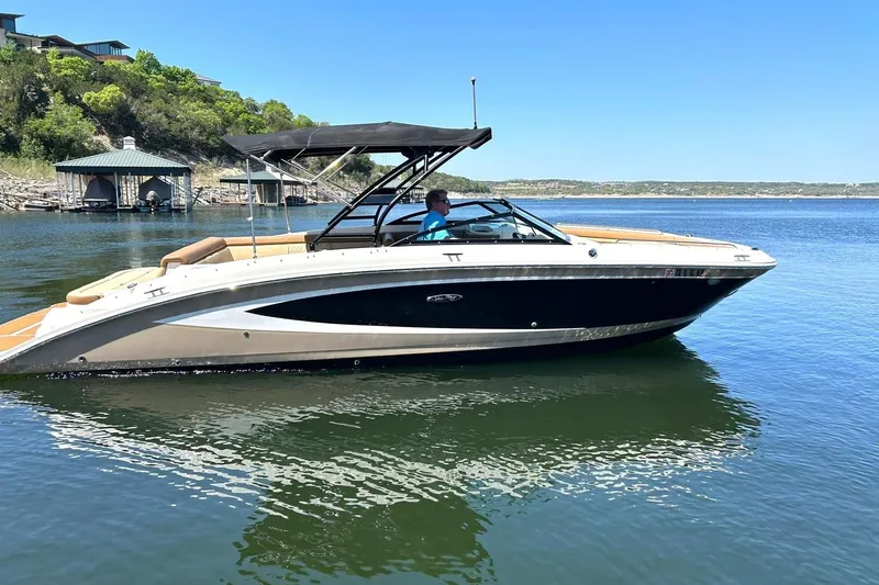 Slide: The Image of 2015 Sea Ray 270 Sundeck boat cruising on a serene lake under clear blue skies. - 17