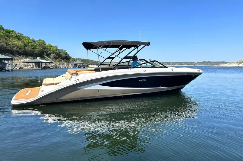 Slide: The Image of 2015 Sea Ray 270 Sundeck boat on calm water, featuring a sleek design and canopy. - 18