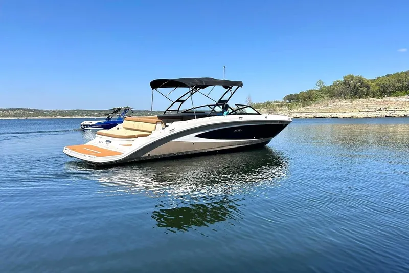 Slide: The Image of 2015 Sea Ray 270 Sundeck boat on a calm lake under clear blue skies. - 19