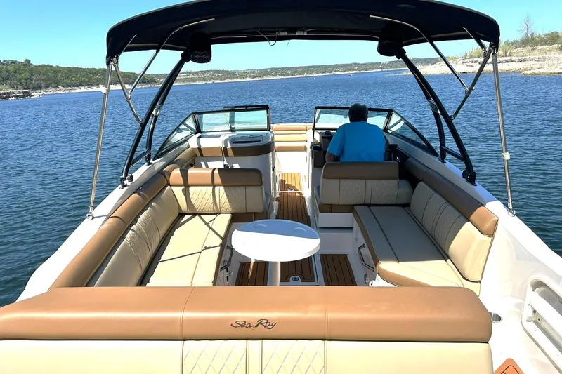 Slide: The Image of 2015 Sea Ray 270 Sundeck boat on a serene lake, featuring spacious seating and canopy. - 2