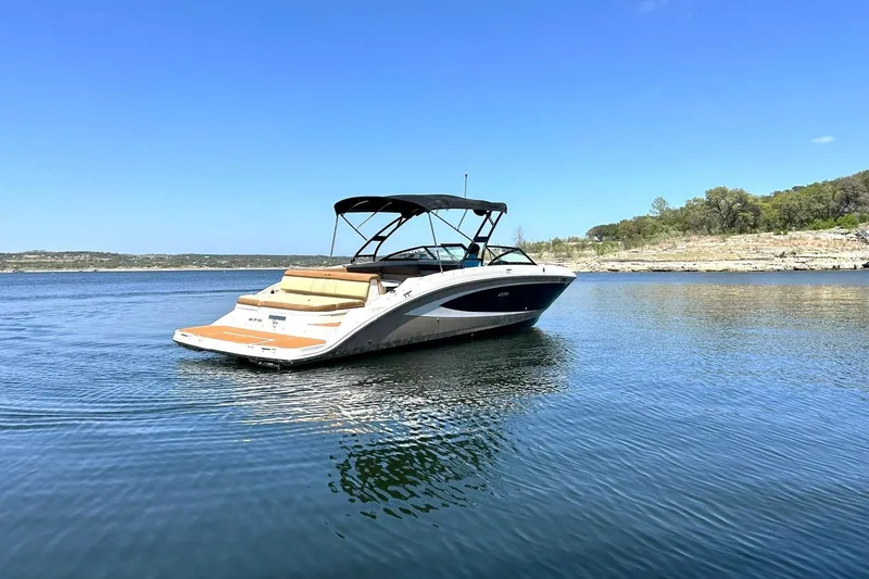 Slide: The Image of 2015 Sea Ray 270 Sundeck boat on calm lake under clear blue sky. - 20