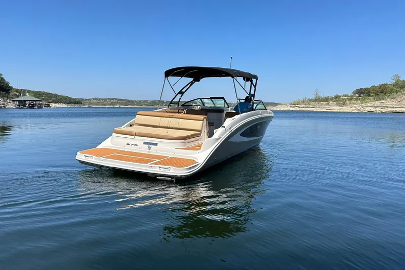 Slide: The Image of 2015 Sea Ray 270 Sundeck boat on calm lake waters under clear blue sky. - 21
