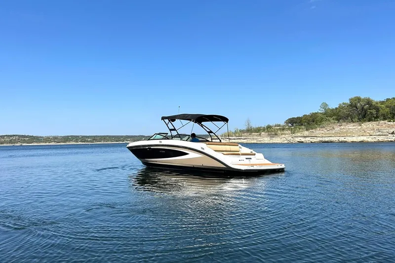 Slide: The Image of 2015 Sea Ray 270 Sundeck boat cruising on a calm lake under clear blue skies. - 24