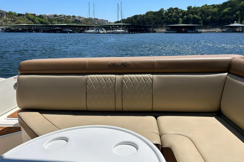 Slide: The Image of 2015 Sea Ray 270 Sundeck interior with tan seating, overlooking a serene lake view. - 31
