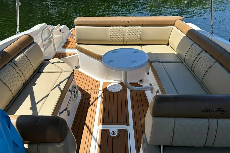 Slide: The Image of 2015 Sea Ray 270 Sundeck interior with luxurious seating and table on water. - 32