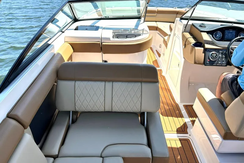 Slide: The Image of Interior of a 2015 Sea Ray 270 Sundeck boat with tan seating and wood flooring. - 37