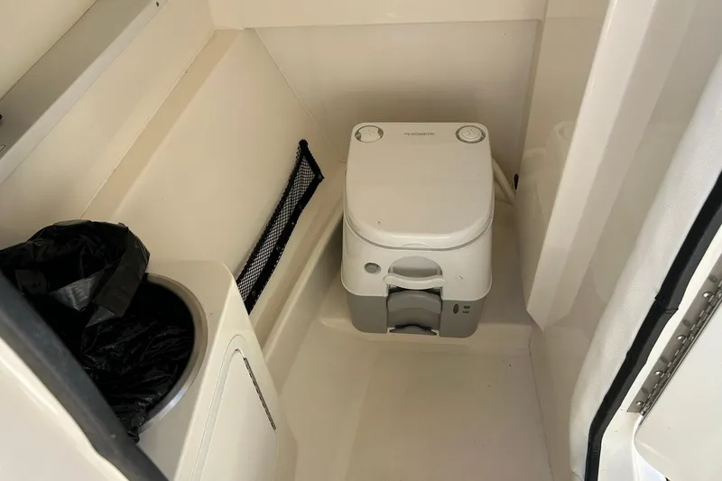 Slide: The Image of Interior of 2015 Sea Ray 270 Sundeck featuring compact marine toilet setup. - 40
