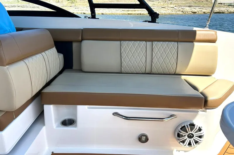 Slide: The Image of 2015 Sea Ray 270 Sundeck interior seating with beige and brown upholstery, near water. - 42