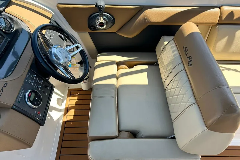 Slide: The Image of 2015 Sea Ray 270 Sundeck helm with steering wheel and beige seating. - 46