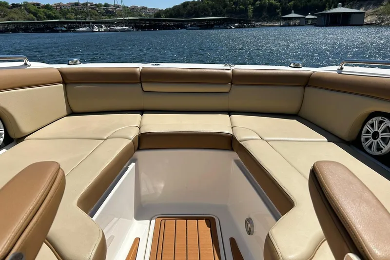 Slide: The Image of 2015 Sea Ray 270 Sundeck boat interior with tan seating, overlooking a scenic waterfront. - 57