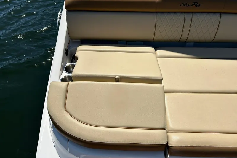 Slide: The Image of 2015 Sea Ray 270 Sundeck boat with beige cushioned seating and cup holders. - 59