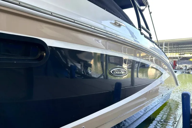 Slide: The Image of 2015 Sea Ray 270 Sundeck boat docked, showcasing sleek design and glossy finish. - 64