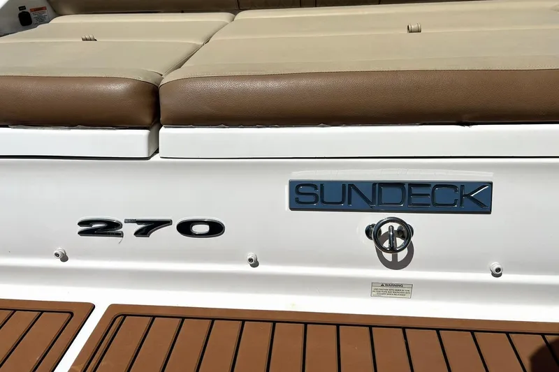 Slide: The Image of 2015 Sea Ray 270 Sundeck boat with cushioned seating and model branding. - 68