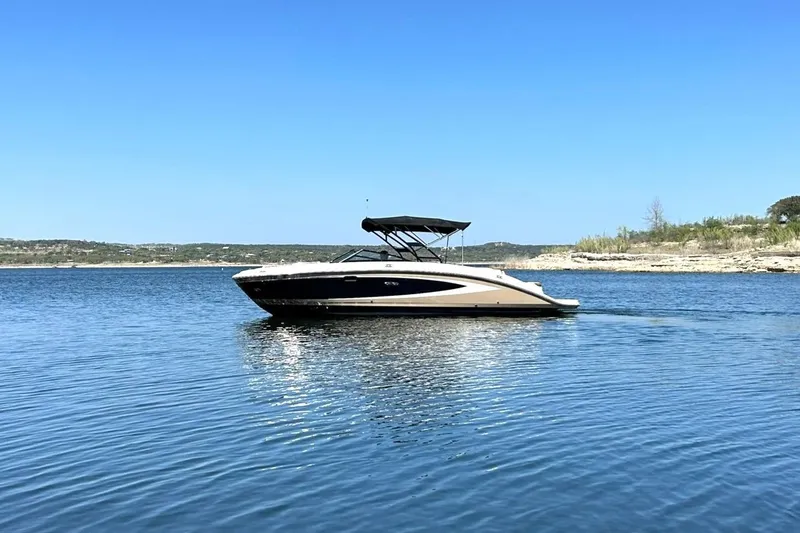 Slide: The Image of 2015 Sea Ray 270 Sundeck boat on calm lake under clear blue sky. - 7
