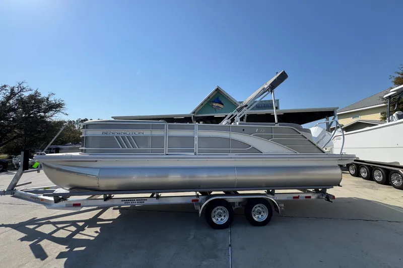 The Image of 2026 Bennington 22 LFB pontoon boat on trailer under clear blue sky. - 1