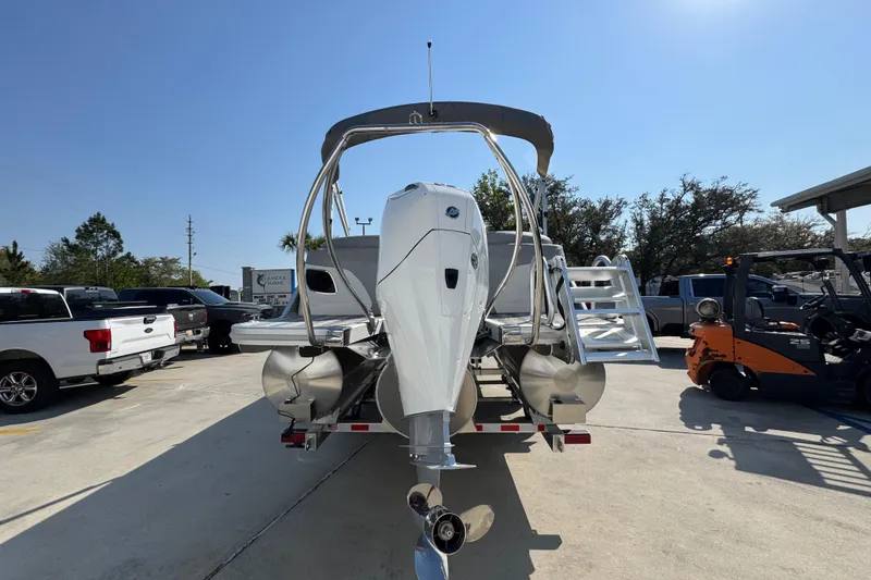 Slide: The Image of 2026 Bennington 22 LFB pontoon boat with outboard motor, parked outdoors. - 12