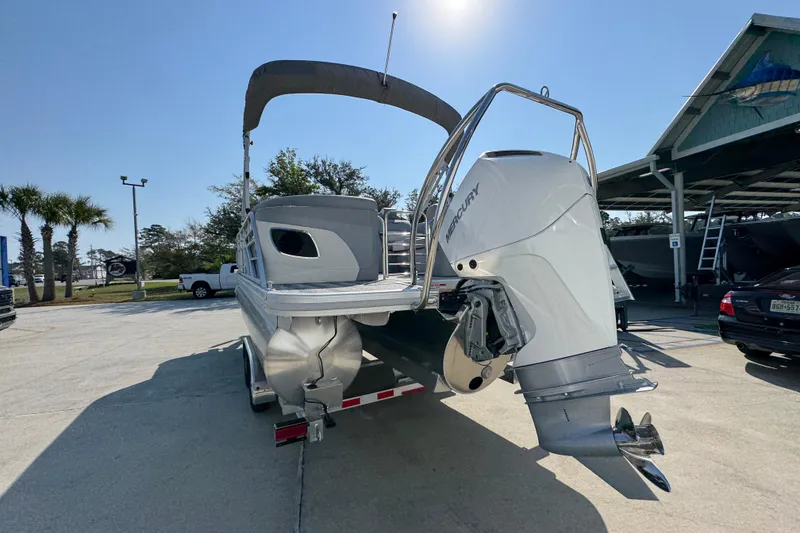 Slide: The Image of 2026 Bennington 22 LFB pontoon boat with Mercury outboard engine, parked outdoors. - 13