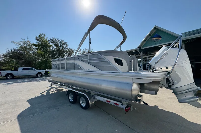 Slide: The Image of 2026 Bennington 22 LFB pontoon boat on trailer, parked outdoors under clear sky. - 15