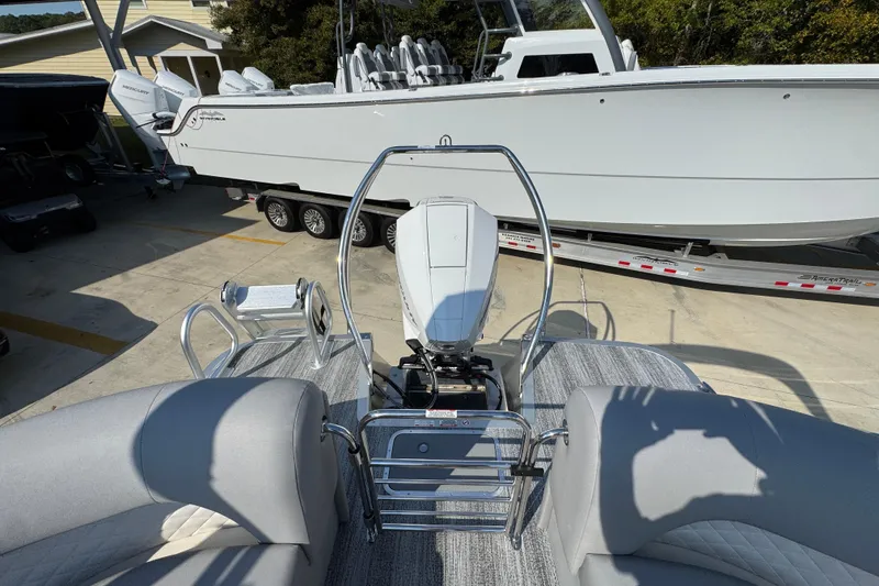 Slide: The Image of 2026 Bennington 22 LFB pontoon boat with outboard motor, parked on a trailer. - 30
