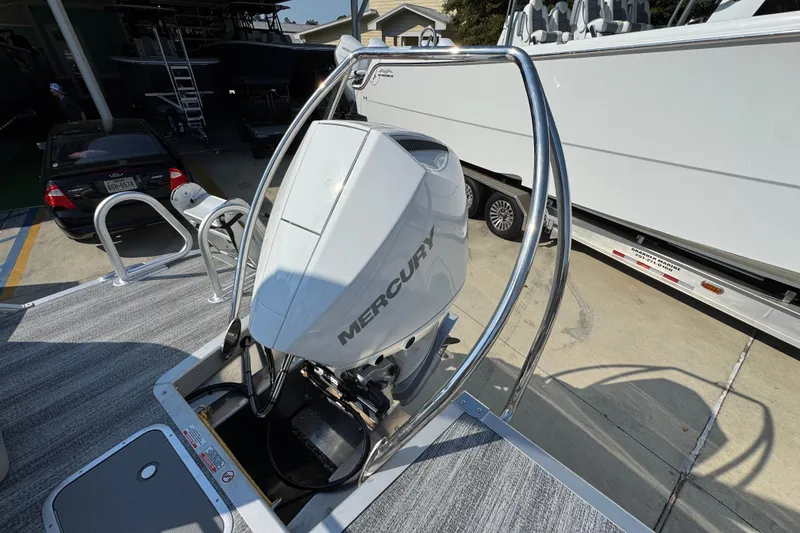 Slide: The Image of 2026 Bennington 22 LFB boat with Mercury outboard motor in a marina setting. - 31